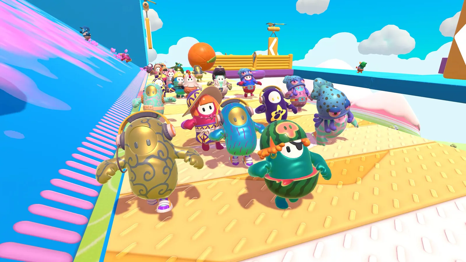 Une grappe de personnages de Fall Guys se bouscule sur la rampe d'un parcours d'obstacles coloré