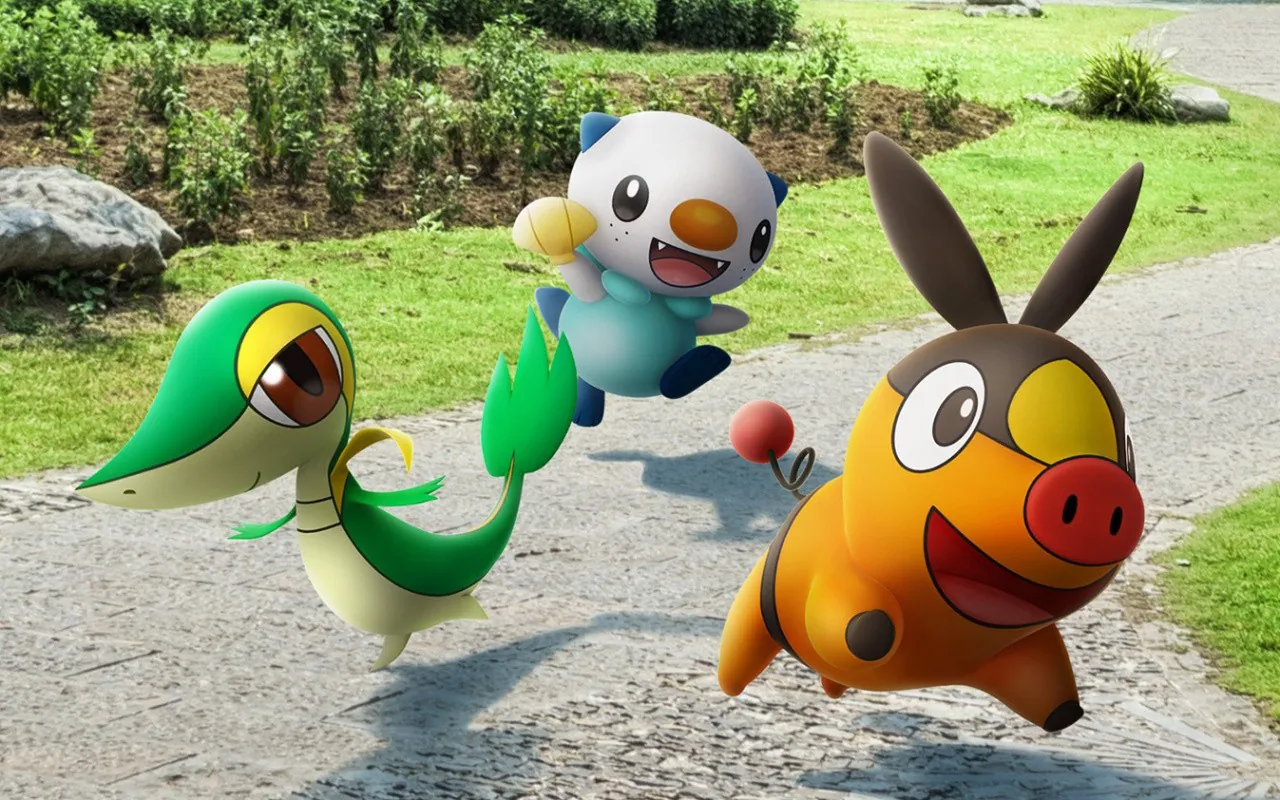 Trois Pokémon posés en réalité augmentée sur un chemin de parc dans Pokémon GO